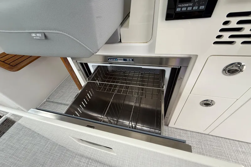 Slide: The Image of 2026 Regal 36 Grande Coupe interior with open stainless steel drawer and control panel. - 45