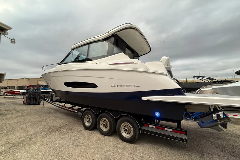 Slide: The Image of 2026 Regal 36 Grande Coupe boat on trailer, side view, overcast sky. - 5