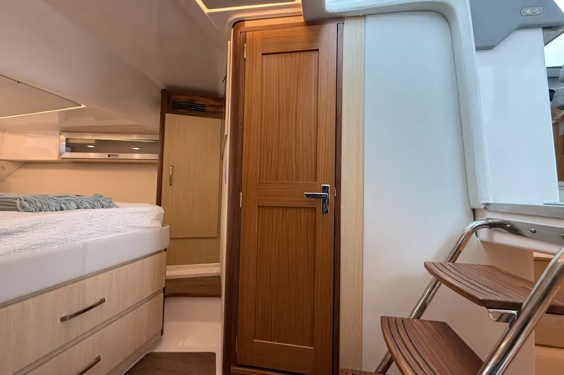 Slide: The Image of Interior of 2026 Regal 36 Grande Coupe yacht, featuring wooden cabinetry and modern design. - 79