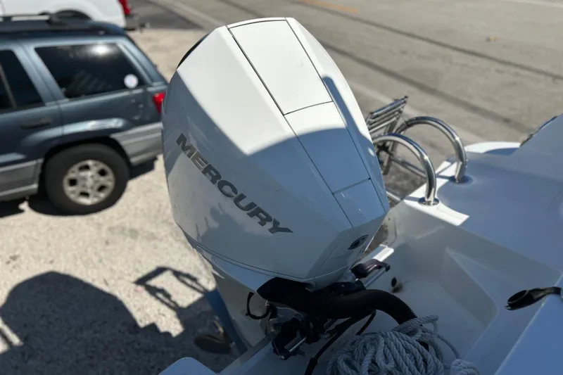 Slide: The Image of 2023 Wellcraft 222 Scarab Offshore with Mercury outboard engine, parked near a vehicle. - 43