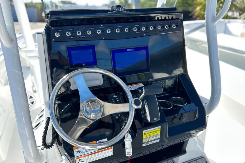 Slide: The Image of 2023 Wellcraft 222 Scarab Offshore boat dashboard with steering wheel and navigation screens. - 6