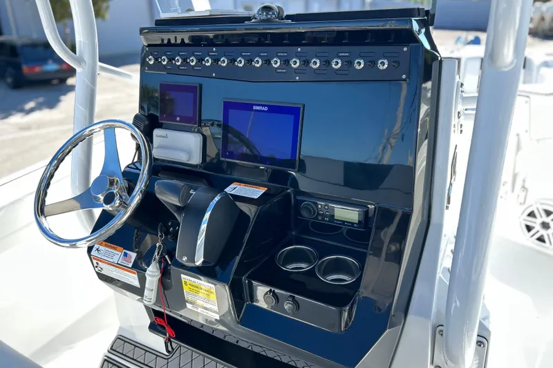 Slide: The Image of 2023 Wellcraft 222 Scarab Offshore boat dashboard with steering wheel and navigation controls. - 7