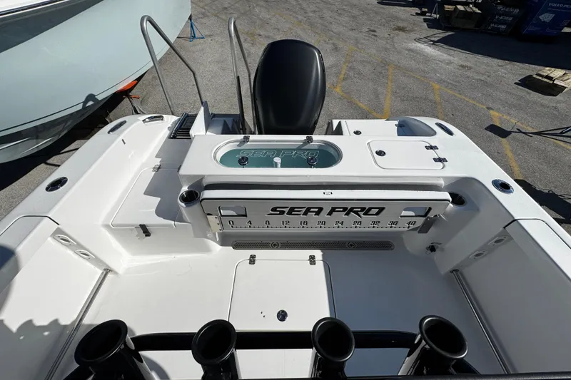 Slide: The Image of 2026 Sea Pro 242 Center Console boat deck with fishing rod holders and storage. - 13