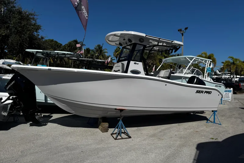 Slide: The Image of 2026 Sea Pro 242 Center Console boat displayed outdoors on stands. - 2