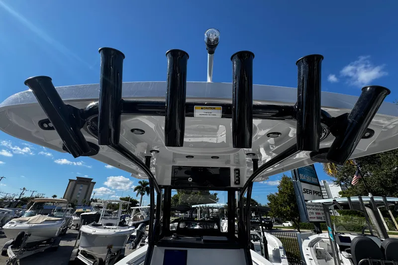 Slide: The Image of 2026 Sea Pro 242 Center Console boat with rod holders under a clear blue sky. - 20