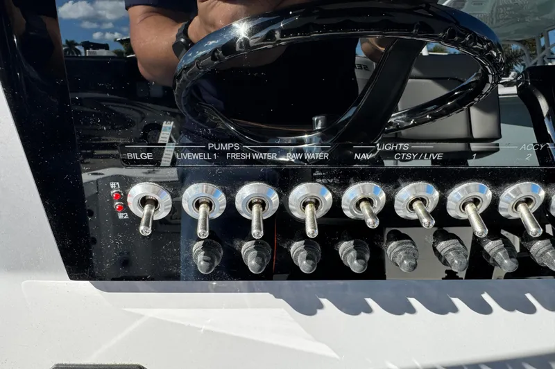 Slide: The Image of 2026 Sea Pro 242 Center Console dashboard with switches for pumps and lights. - 26
