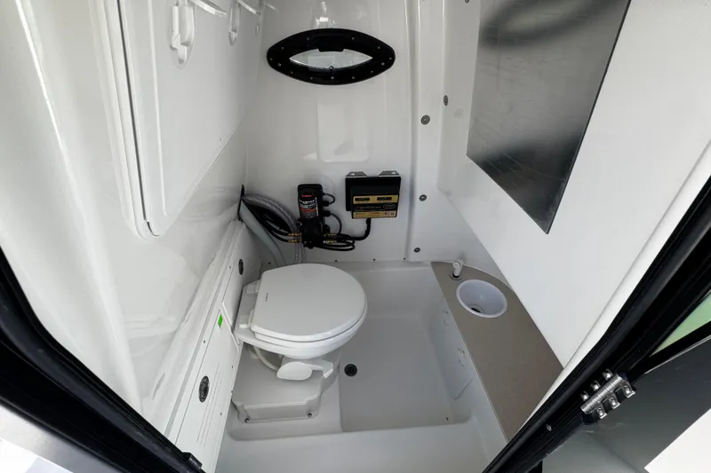 Slide: The Image of 2026 Sea Pro 242 Center Console boat interior with compact marine toilet and sink. - 47