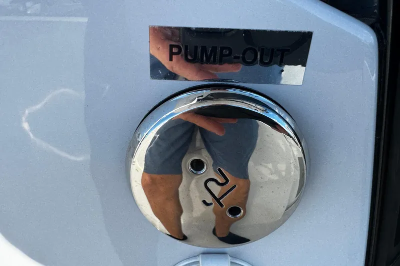 Slide: The Image of 2026 Sea Pro 242 Center Console pump-out port with reflective chrome finish. - 52