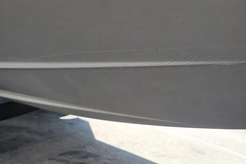 Slide: The Image of Close-up of 2024 Tahoe 1950 boat hull, showing smooth white surface. - 10