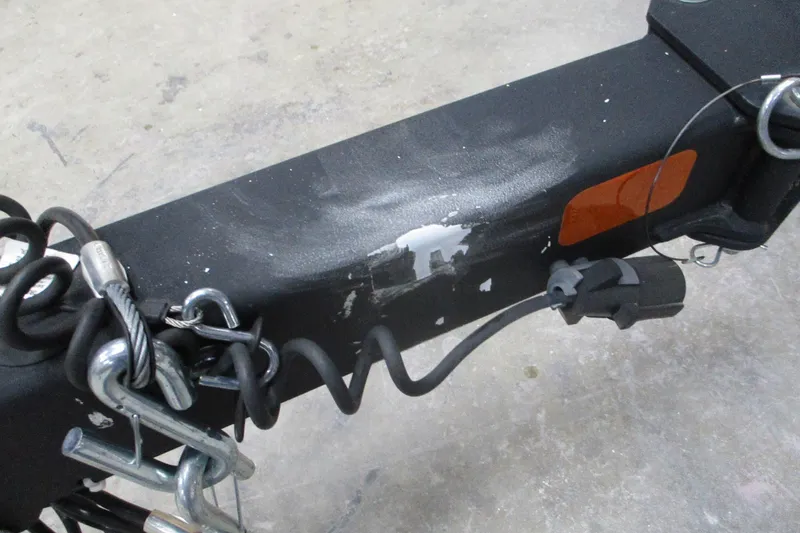 Slide: The Image of Trailer hitch of a 2024 Tahoe 1950 with safety chains and electrical connector. - 12