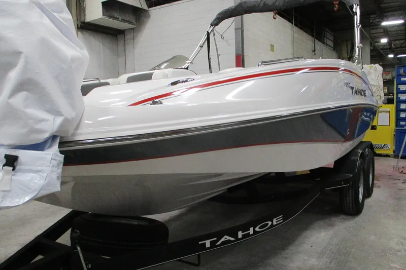Slide: The Image of 2024 Tahoe 1950 boat in a warehouse, showcasing sleek design and modern features. - 2