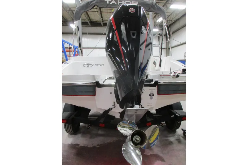 Slide: The Image of 2024 Tahoe 1950 boat with powerful outboard motor in a showroom. - 6