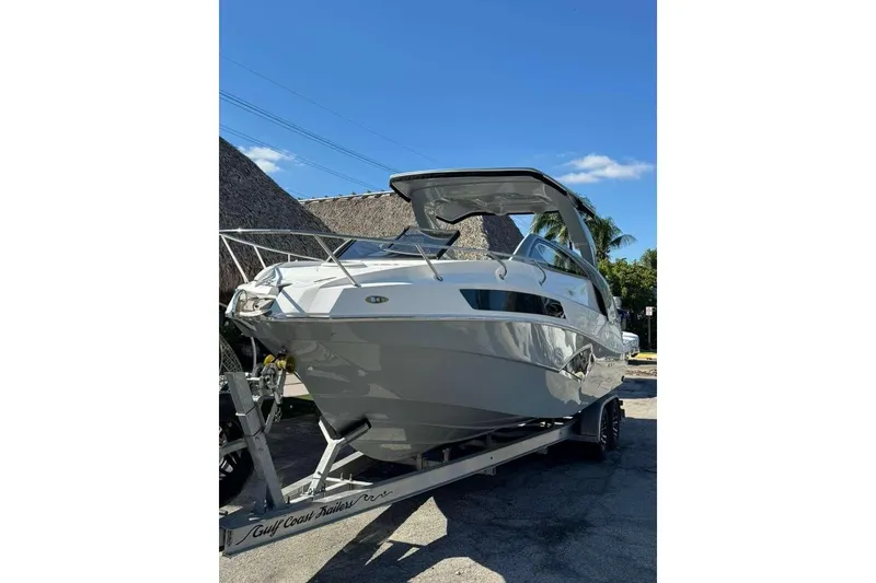 The Image of 2024 NX Boats NX290 on trailer, sleek design under clear blue sky. - 1