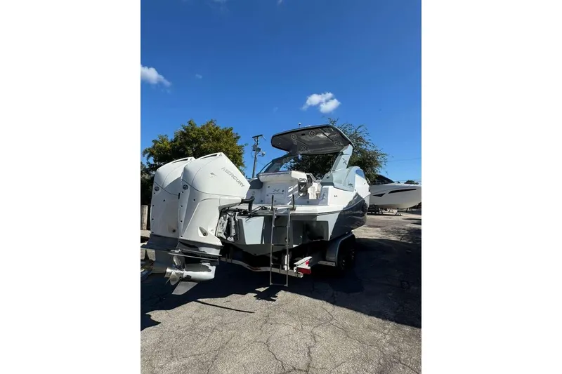 Slide: The Image of 2024 NX Boats NX290 with dual Mercury outboard engines, parked outdoors. - 4