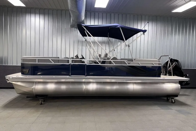 Slide: The Image of 2026 Avalon Venture 2385 QL pontoon boat in a showroom with blue canopy. - 2