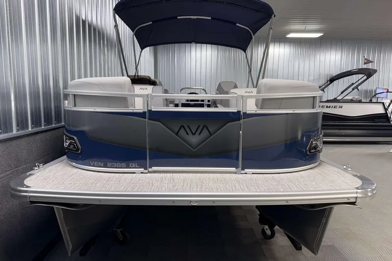 Slide: The Image of 2026 Avalon Venture 2385 QL pontoon boat in showroom, featuring sleek design and canopy. - 3