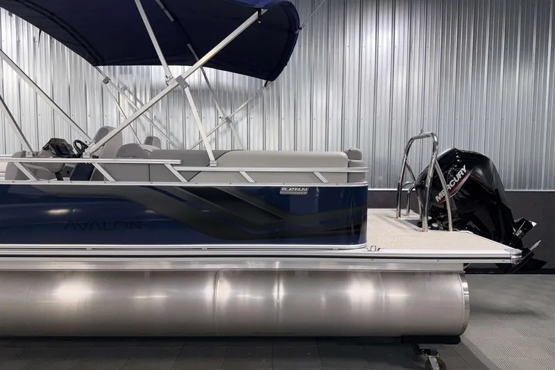 Slide: The Image of 2026 Avalon Venture 2385 QL pontoon boat with Mercury outboard motor in a showroom. - 6