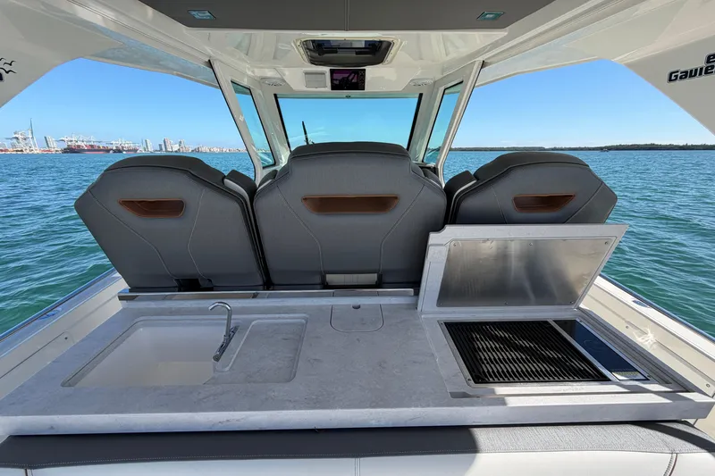 Slide: The Image of 2022 Tiara Yachts 34 LS interior with seating, sink, and grill, overlooking the ocean. - 16