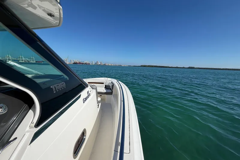 Slide: The Image of 2022 Tiara Yachts 34 LS cruising on open water under clear blue skies. - 21