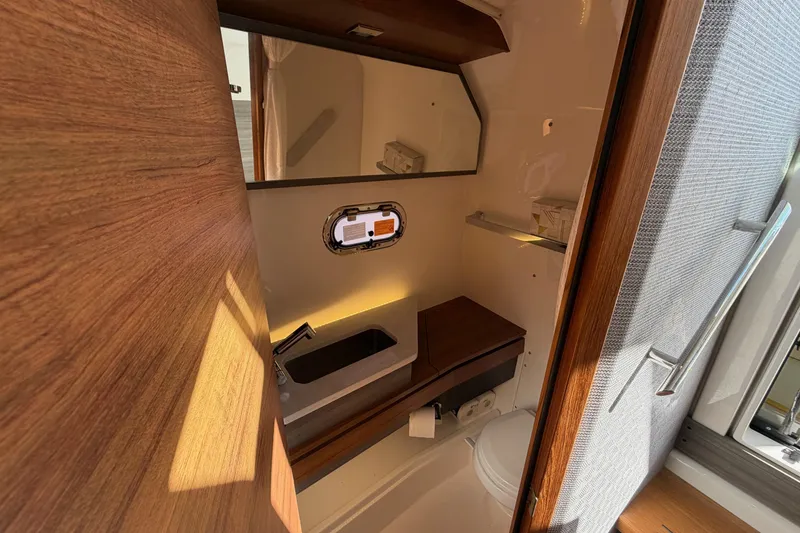 Slide: The Image of 2022 Tiara Yachts 34 LS bathroom interior with sink, mirror, and wooden accents. - 34