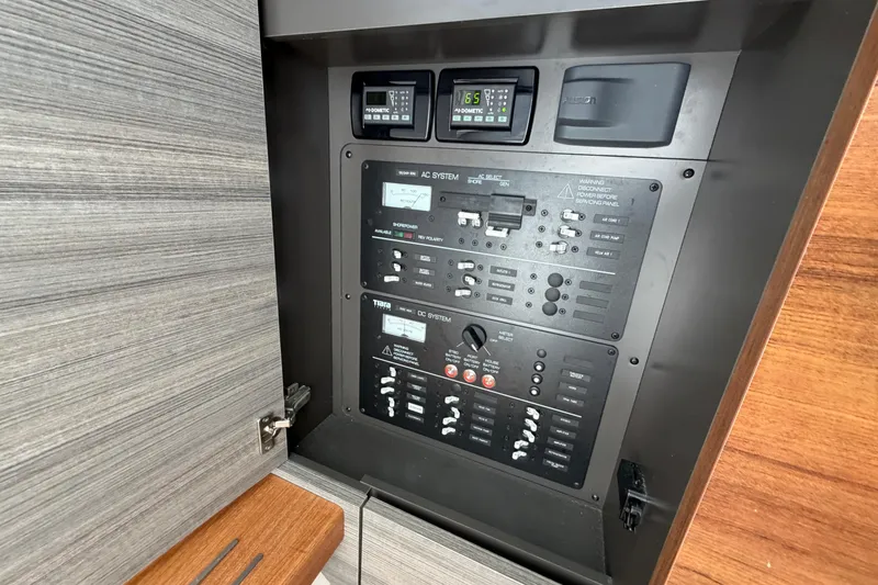 Slide: The Image of Electrical control panel on a 2022 Tiara Yachts 34 LS, featuring AC and DC systems. - 35