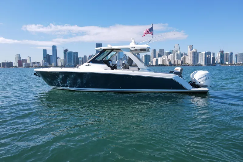 Slide: The Image of 2022 Tiara Yachts 34 LS cruising on water with city skyline backdrop. - 4