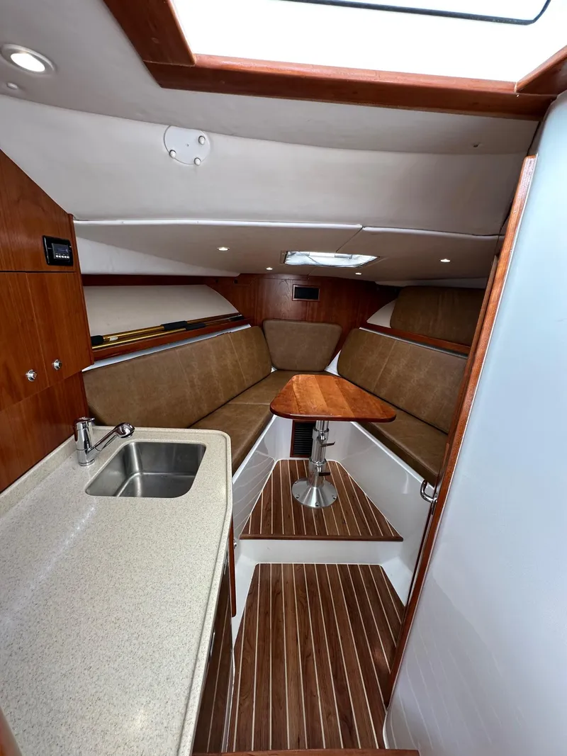 Slide: The Image of 2017 Albemarle Express cabin interior with kitchenette, seating, and wooden accents. - 11