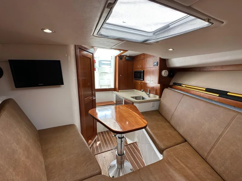 Slide: The Image of 2017 Albemarle Express cabin interior with seating, table, and kitchenette. - 12