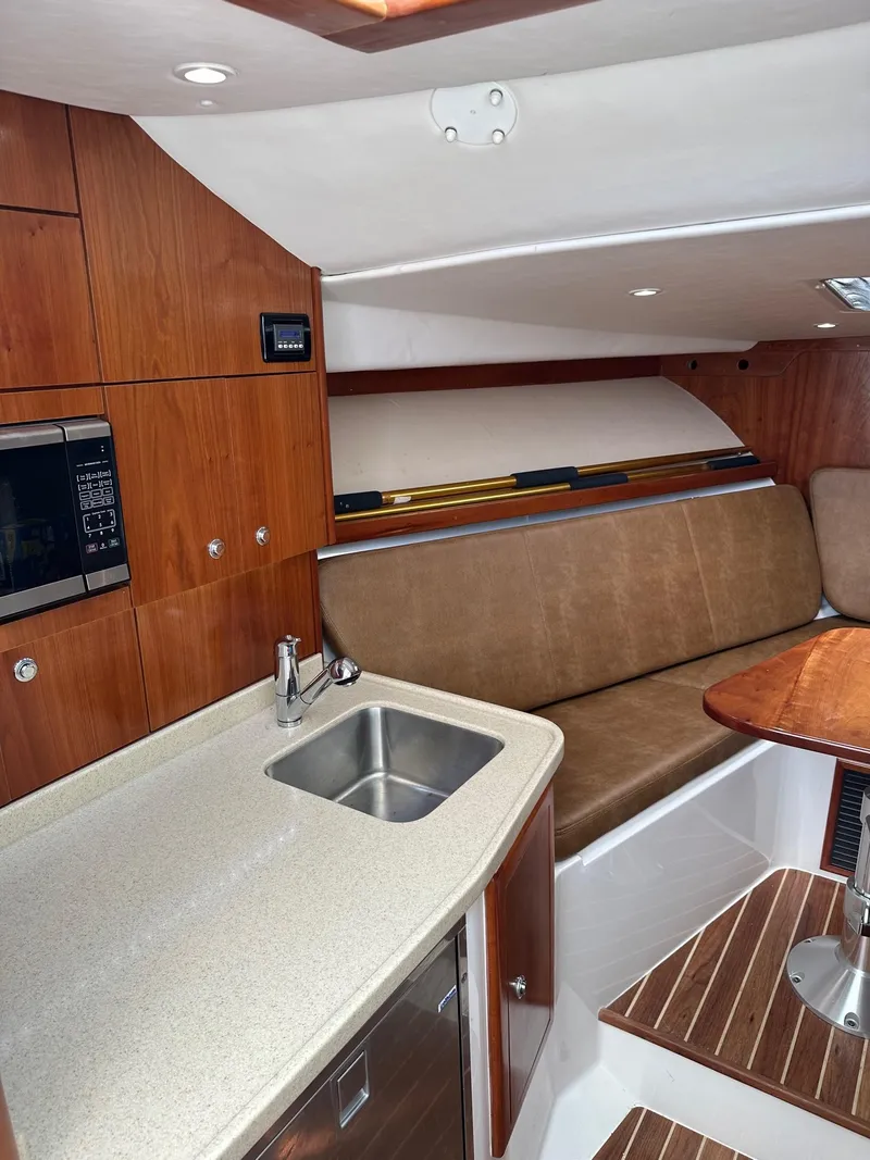 Slide: The Image of 2017 Albemarle Express cabin interior with kitchenette, sink, and seating area. - 13