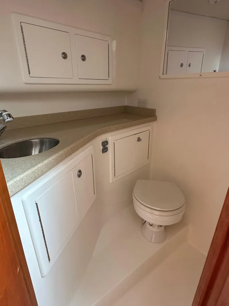 Slide: The Image of 2017 Albemarle Express boat bathroom with sink, toilet, and storage cabinets. - 14