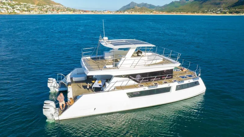 Slide: The Image of 2024 Leeuwin 55 yacht with a person relaxing on deck, surrounded by blue ocean. - 27