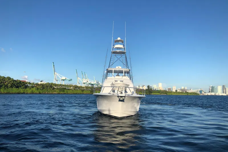 Slide: The Image of 2006 Hatteras 64 Convertible yacht on water with city skyline background. - 26