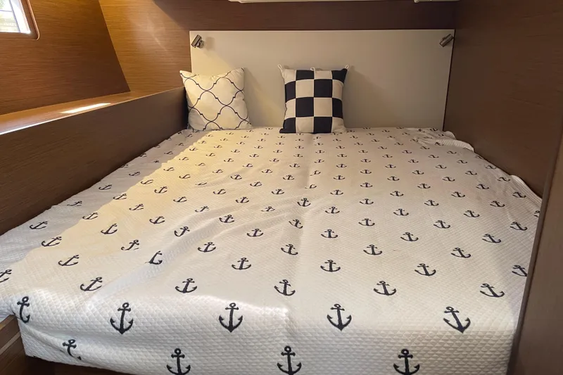 Slide: The Image of Cozy cabin bed in 2024 Beneteau Oceanis 51.1 yacht with nautical-themed bedding. - 9