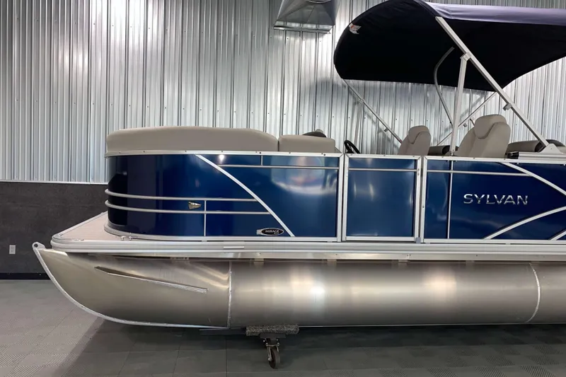 Slide: The Image of 2026 Sylvan Mirage 8522 LZ pontoon boat with blue exterior in showroom. - 16