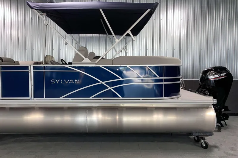 Slide: The Image of 2026 Sylvan Mirage 8522 LZ pontoon boat with Mercury outboard motor in showroom. - 18