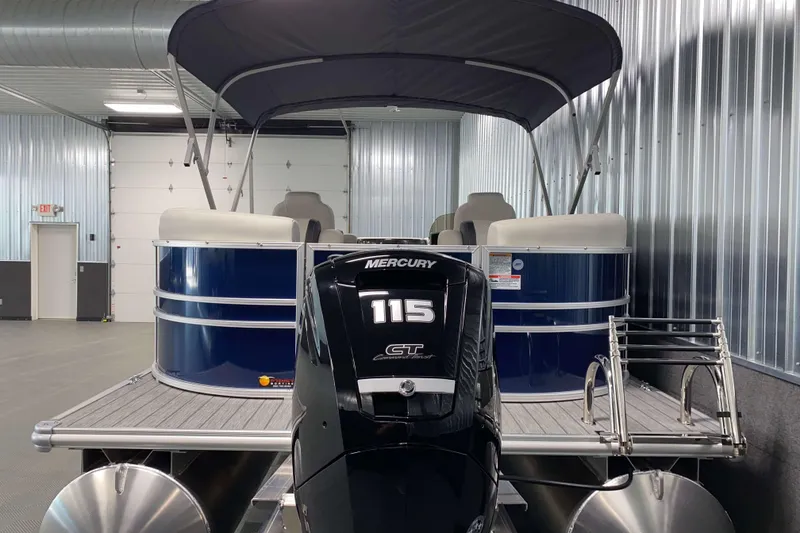 Slide: The Image of 2026 Sylvan Mirage 8522 LZ pontoon boat with Mercury 115 engine in a metal-walled showroom. - 20