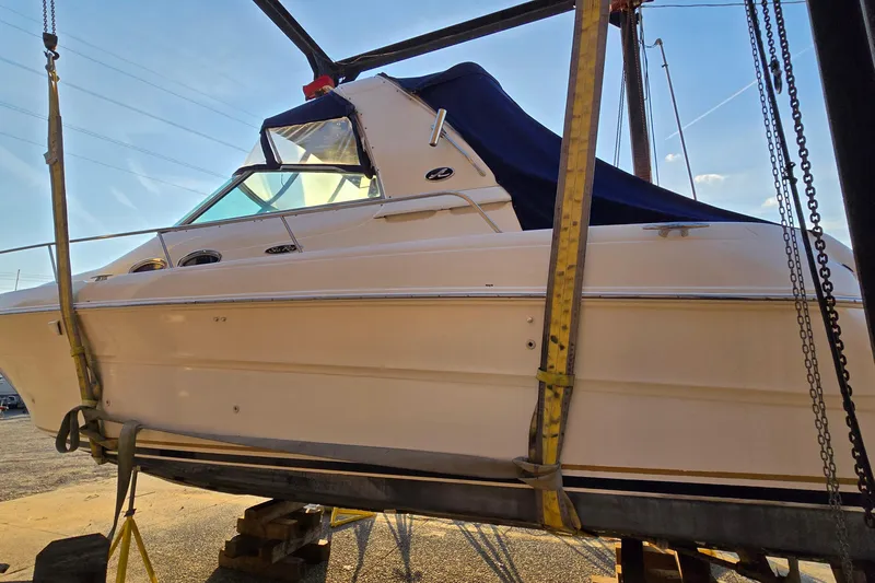 The Image of 2001 Sea Ray 310 Sundancer boat on lift under clear blue sky. - 0