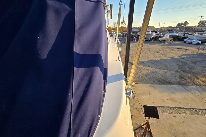 Slide: The Image of 2001 Sea Ray 310 Sundancer docked, featuring blue canvas cover and marina background. - 13