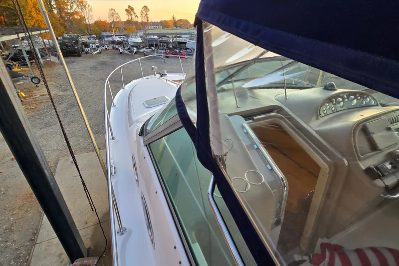 Slide: The Image of 2001 Sea Ray 310 Sundancer boat docked, showcasing cockpit and marina view. - 14