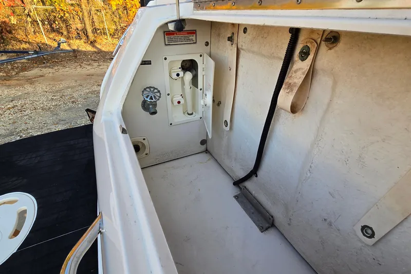 Slide: The Image of 2001 Sea Ray 310 Sundancer boat compartment with utility connections and storage space. - 17