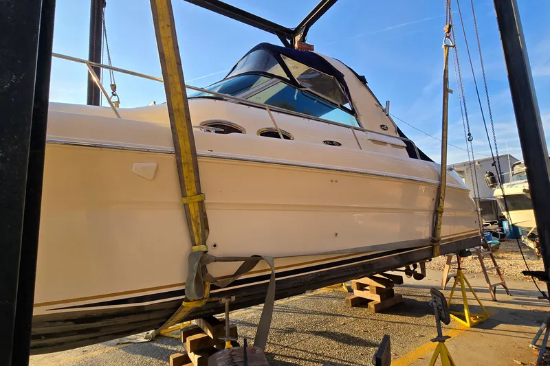 Slide: The Image of 2001 Sea Ray 310 Sundancer yacht suspended on a lift for maintenance. - 2