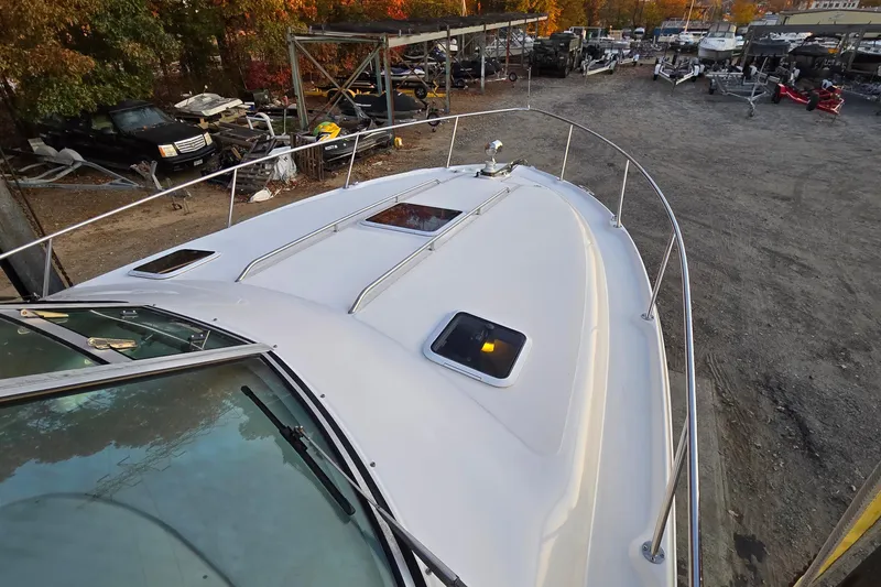 Slide: The Image of 2001 Sea Ray 310 Sundancer boat on dry dock, surrounded by autumn foliage. - 20