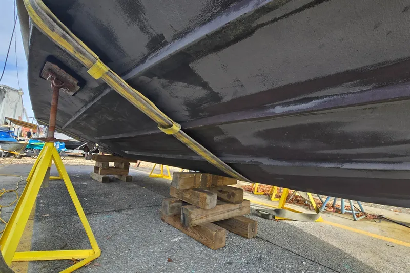 Slide: The Image of 2001 Sea Ray 310 Sundancer boat hull on blocks, undergoing maintenance. - 24