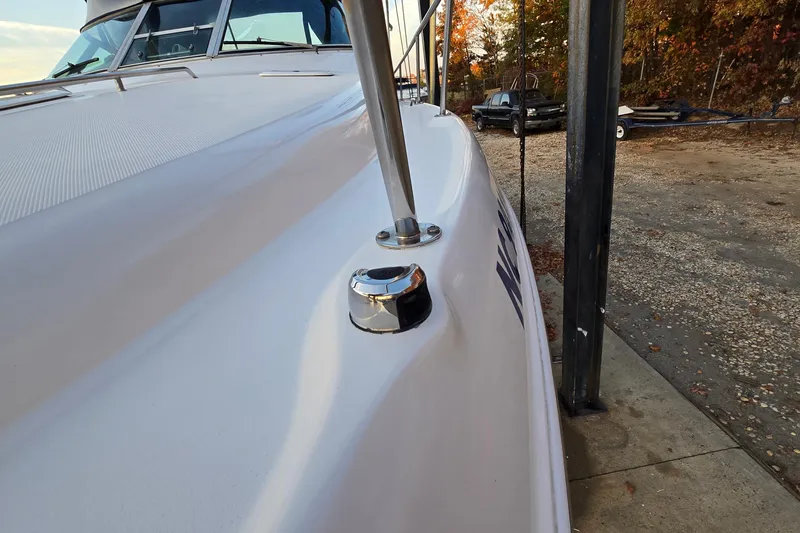 Slide: The Image of 2001 Sea Ray 310 Sundancer boat docked, showcasing sleek design and chrome fittings. - 25