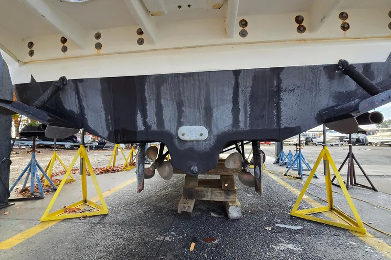 Slide: The Image of 2001 Sea Ray 310 Sundancer boat hull on stands, showcasing propellers and rudders. - 26