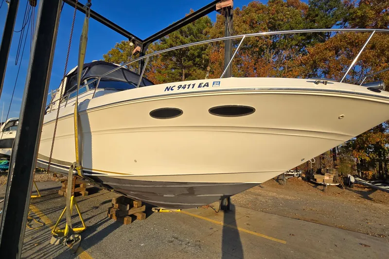 Slide: The Image of 2001 Sea Ray 310 Sundancer boat on lift, surrounded by autumn trees. - 3