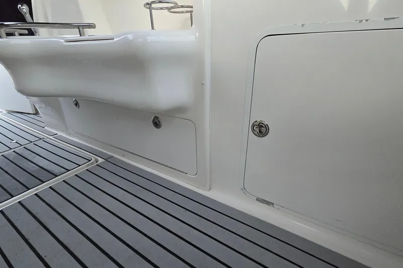 Slide: The Image of 2001 Sea Ray 310 Sundancer boat deck with storage compartment and sleek design. - 31