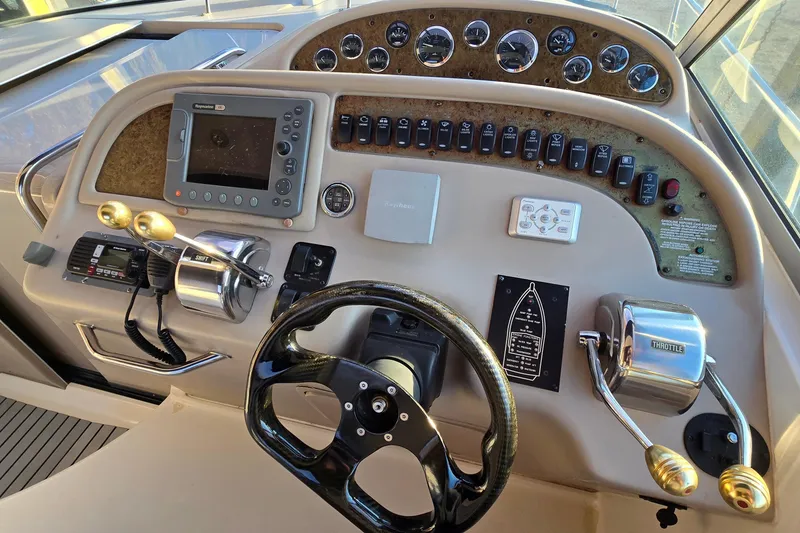 Slide: The Image of Control panel of a 2001 Sea Ray 310 Sundancer boat with steering wheel and navigation instruments. - 38