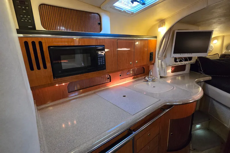 Slide: The Image of 2001 Sea Ray 310 Sundancer galley with microwave, sink, and TV. - 42