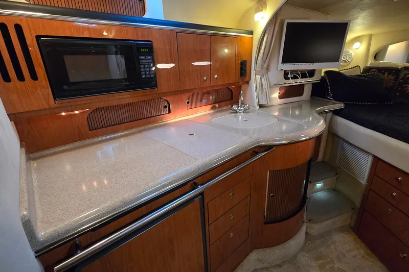 Slide: The Image of 2001 Sea Ray 310 Sundancer interior with kitchenette, microwave, and TV. - 43